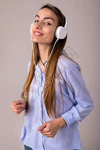 美丽的年轻女士用耳机聆听音乐图片