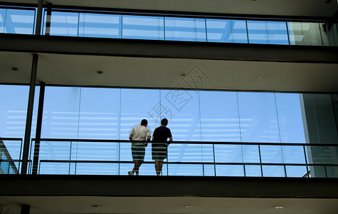 在现代办公楼内装有全景窗的地有两名青年男子的影视图片