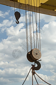 两根吊钩挂在铁链的老路起重机上蓝色天空背景图片