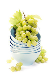 把碗和新鲜绿葡萄堆在白色之上图片