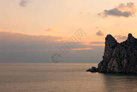 黑海岩石岸的橙色日落图片