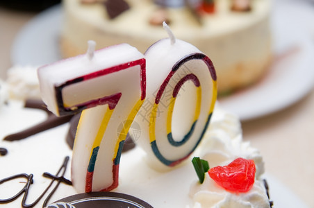 70年的蜡烛在奶油蛋糕上图片