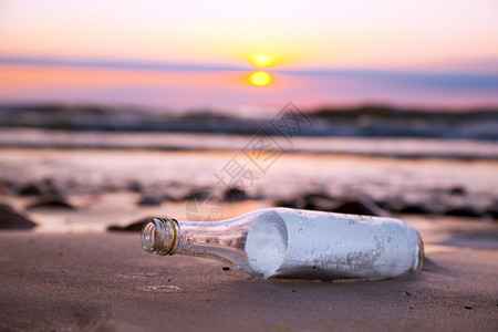 日落时在海滩的瓶子里留言图片