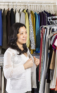 穿着白毛衣的柜里成年亚洲女人的垂直肖像图片