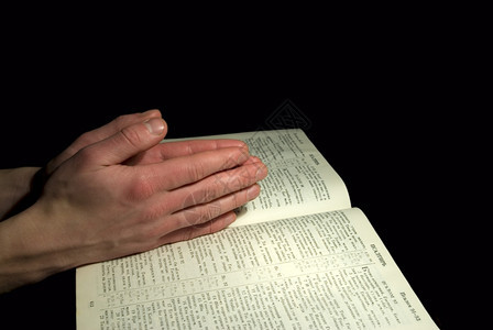 一个男人的手在圣经上拍祷告背景图片