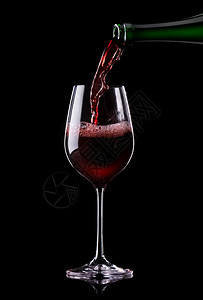 红葡萄酒被倒在杯子上黑色背景图片