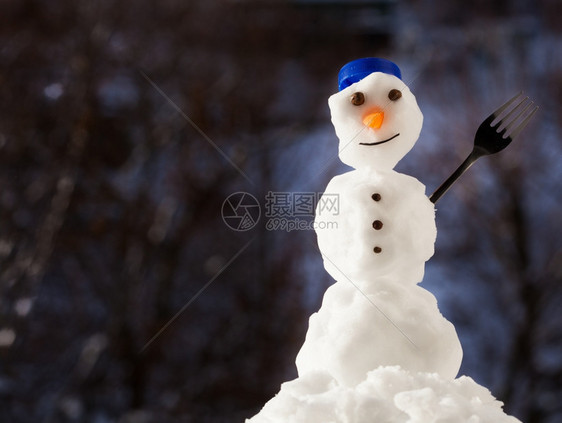 圣诞小雪人快乐蓝螺帽顶端是子和叉冬季节特别模糊的背景图片