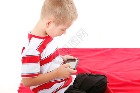小男孩玩智能手机游戏或阅读白背景孤立的短信图片