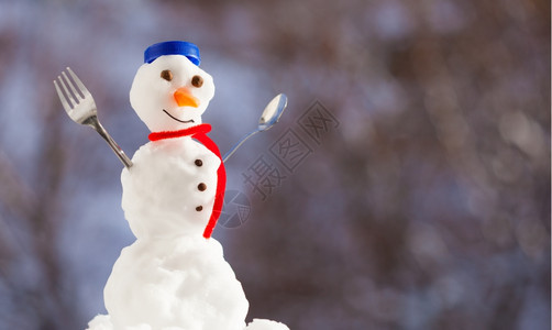 小快乐的圣诞节雪人蓝螺帽顶部的色丝帽子红围巾外出有叉茶匙冬季节模糊的背景图片