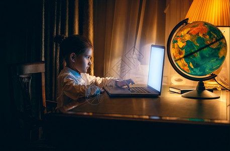小女孩奔跑晚上在笔记本电脑做家庭作业的小女孩肖像背景