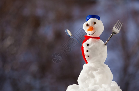 小快乐的圣诞节雪人蓝螺帽顶部的色丝帽子红围巾外出有叉茶匙冬季节模糊的背景图片