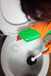 女人用刷子橙色橡皮手套洗马桶碗干净你的房子图片