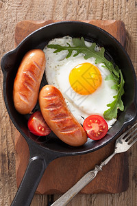 平底锅里的煎鸡蛋和香肠番茄图片