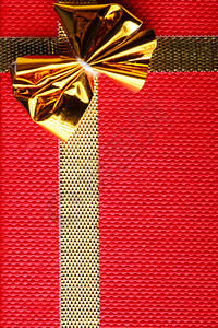 礼品盒封装金丝带和彩礼的红背景的礼品包图片