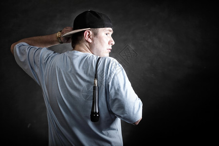 Rapper态度说唱歌手跳舞表演年轻人带帽子麦克风背面观看黑色的粗野背景图片