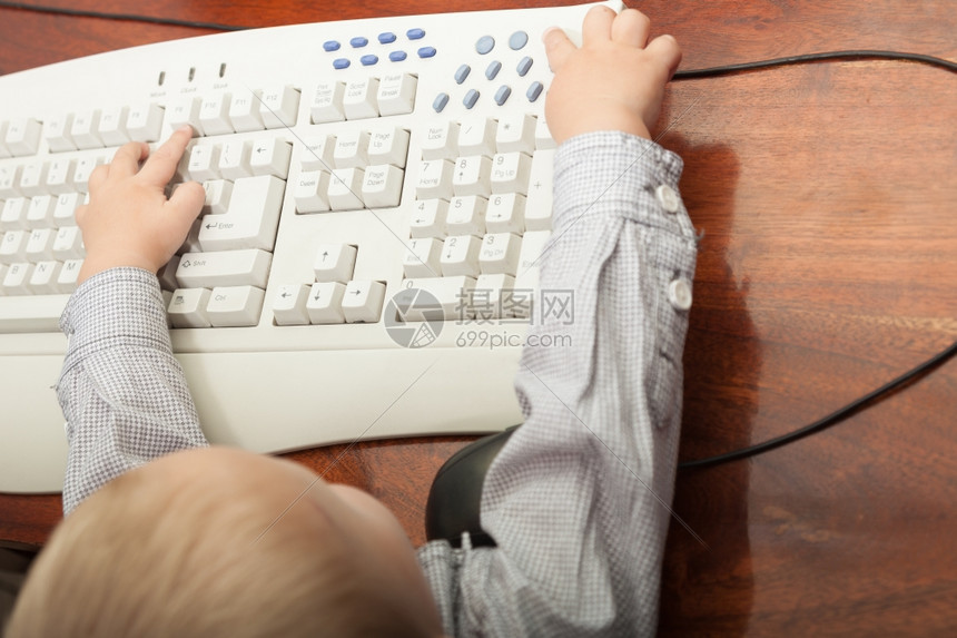 快乐的童年聪明小男孩在家里的台式电脑上玩耍技术图片