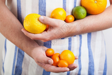 握着各种柑橘水果的手图片