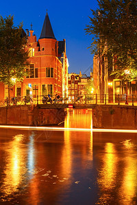 荷兰阿姆斯特丹运河桥梁典型房屋和自行车的夜景图片