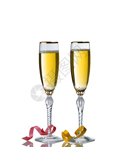 盛满金香槟的优美酒杯被白色背景隔绝反光和派对彩带图片