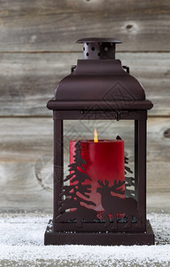 太阳灯的垂直图像里面有红蜡烛在生锈的木材上烧着图片