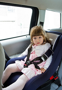 可爱的小女孩坐在安全座位上笑着图片