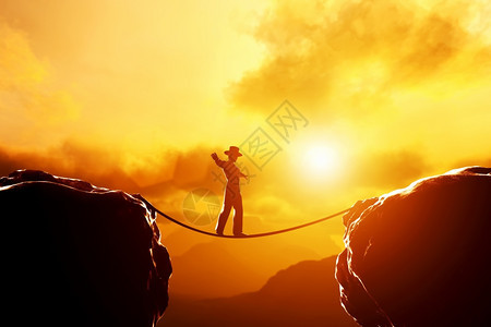 日落时人们戴着帽子走在山顶上靠绳子平衡商业概念冒险挑战集中图片