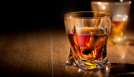 木制桌上的威士忌杯子图片