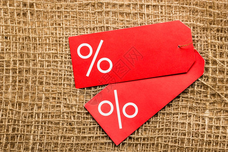 购物和销售概念两个红色价格标签布表面背景上有百分数符号复制空间图片