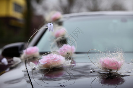 带有粉红色花和丝带装饰的婚礼轿车图片
