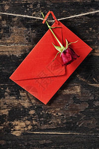 红包和玫瑰挂在衣绳上旧木本底图片