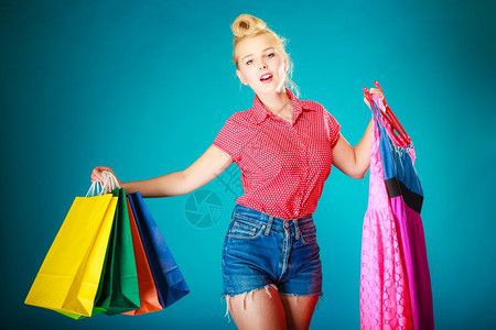 粉色衣服客户拿着鲜艳的纸袋蓝色零售和销工作室拍摄图片