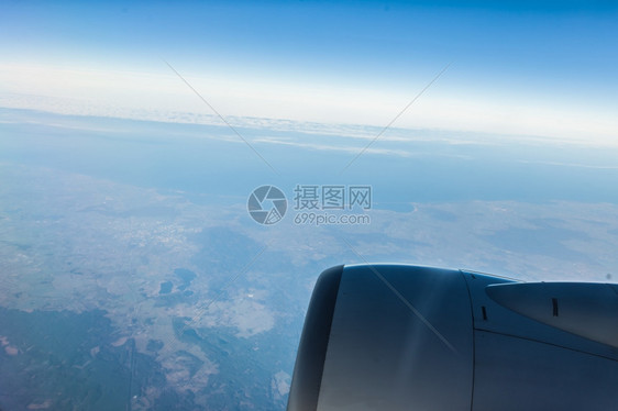 蓝天空和引擎从云中飞行的机窗口查看天景云色Bird39眼睛图片