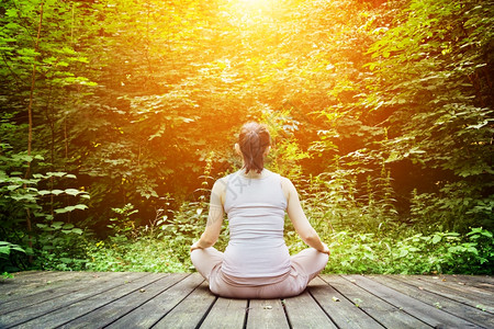 青年妇女坐在木地板上的森林里冥想Zen冥想放松精神健康呼吸图片