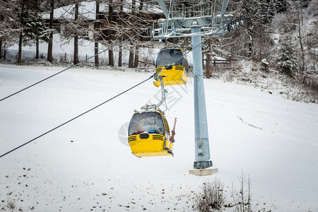 奥地利阿尔卑斯山滑雪坡上两辆黄色电缆汽车图片