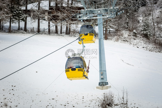 奥地利阿尔卑斯山滑雪坡上两辆黄色电缆汽车图片