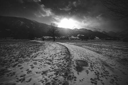 日落时阿尔卑斯山白黑雪路景色高清图片