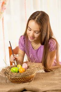 女孩给在鸟窝里的彩蛋上色图片