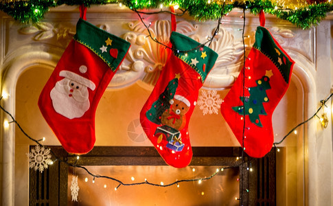挂在装饰的壁炉上挂着三只红圣诞丝袜图片