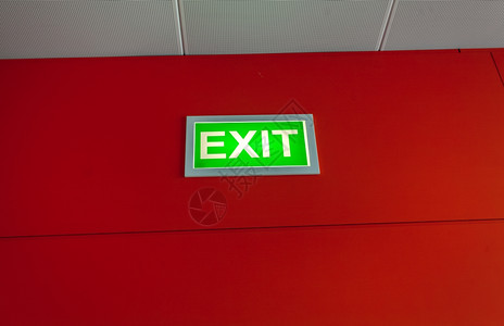 红墙上亮着绿色出口标志图片