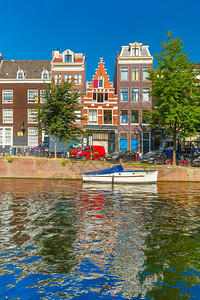 荷兰阿姆斯特丹运河和典型房屋船只和自行车的城市景象图片