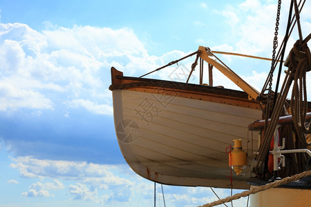 蓝天背景的旧木救生艇图片