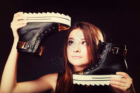 女喜欢穿鞋的青少年时装概念女模特少孩在黑色上穿着时装运动鞋图片