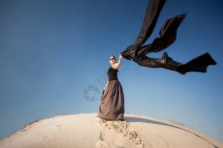 照片中感女在风天沙丘上披着黑布的照片图片