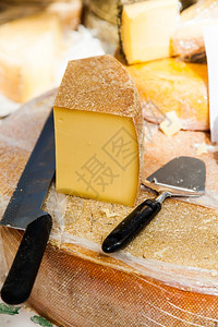 用刀子切在木制桌上的奶酪背景图片
