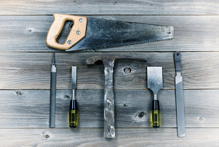由锤子金属文件手锯和皮革组成的生锈木板旧工具概念图片