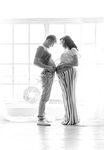 怀孕妻子和丈夫站立摸肚子的黑白搞笑镜头图片