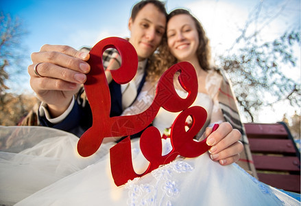 快乐的新婚夫妇拿着爱的字条符号近距离肖像图片