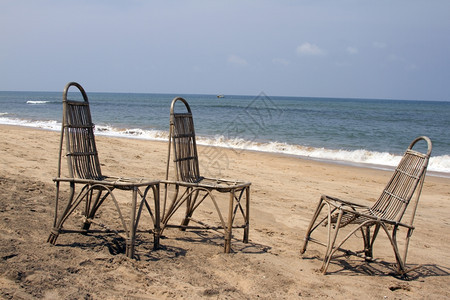 三个小椅子站在海滩上等待人们对着大海图片