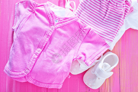 粉色桌上的婴儿衣物堆叠的婴儿衣物图片