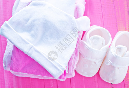 粉色桌上的婴儿衣物堆叠的婴儿衣物图片